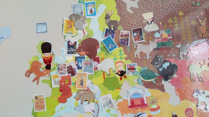 Picture of a world map with images of book covers stuck on it showing the origin of the books