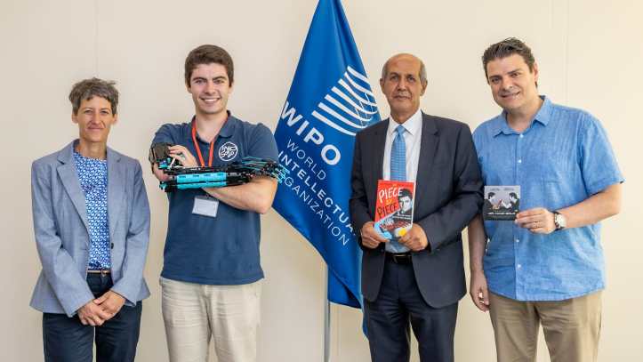 Photo of David and Ferran beside WIPO flag with two WIPO representatives.